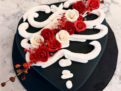 A heart shaped cake with flowers and a skeleton design
