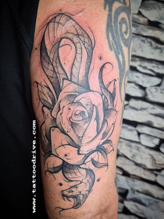 Sketch-Tattoo einer schwarzen Schlange mit Rose auf dem Oberarm