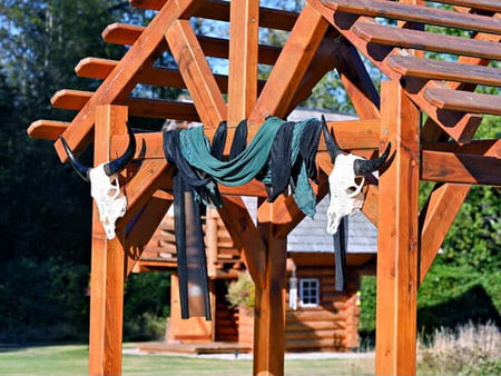 Wooden gazebo with white cow skulls and green and black draped cloth