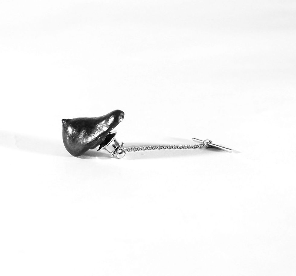 Thumbnail: Breast shaped tie tack with a dark patina. 