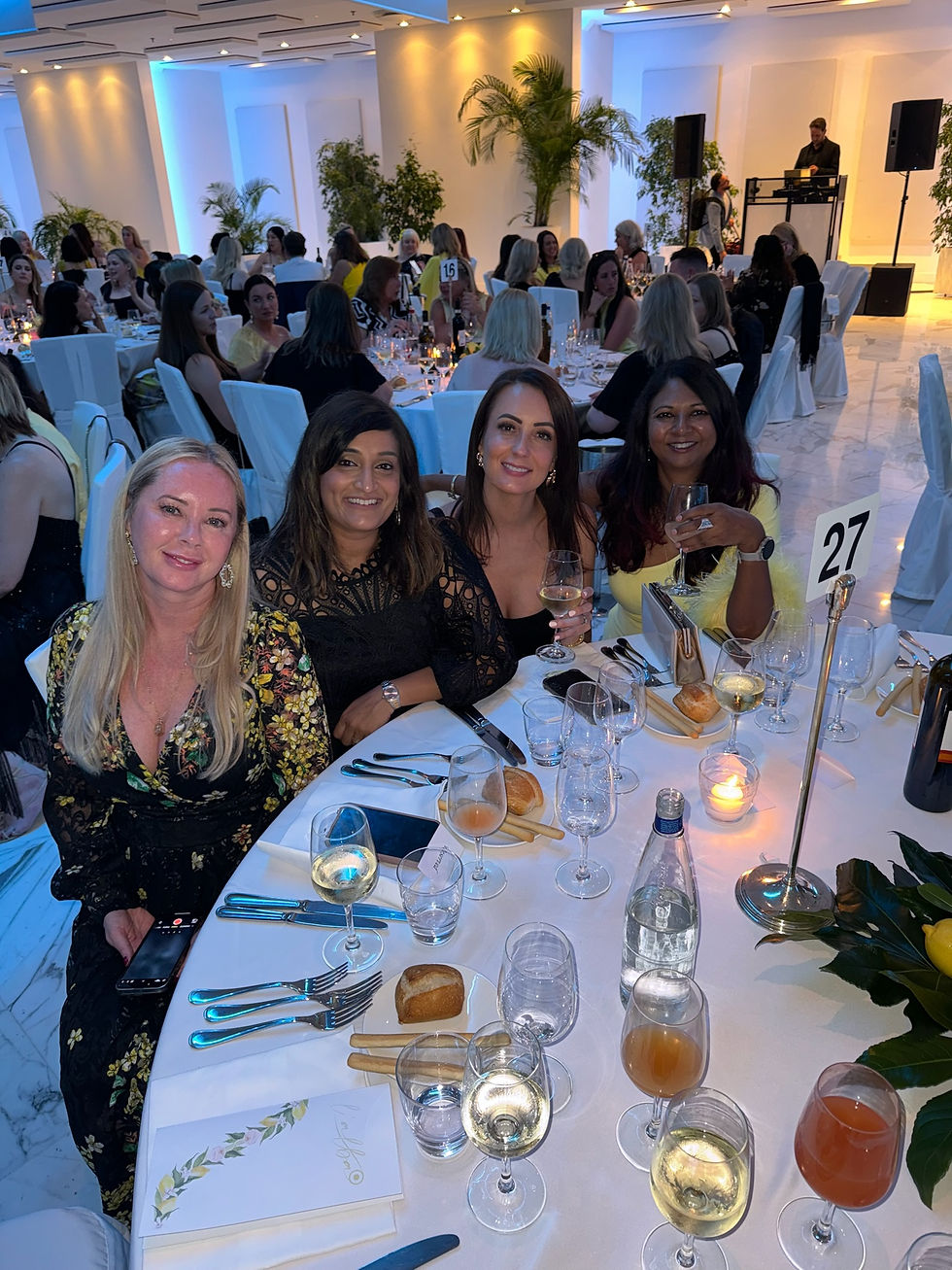 Four women sitting at a round table for dinner at a gala event