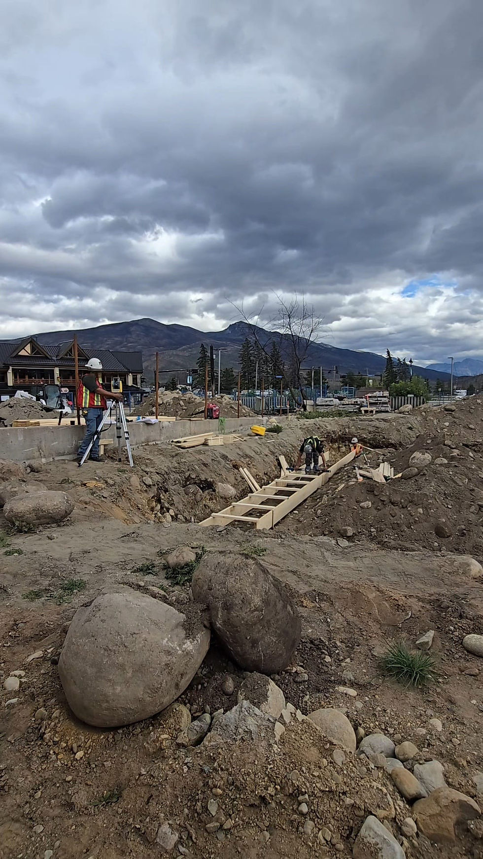 Skilled carpenters installing professional structural framing and wooden formwork for a large-scale construction foundation.