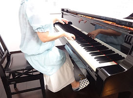 ピアノを弾く女性 ミントグリーンのトップス