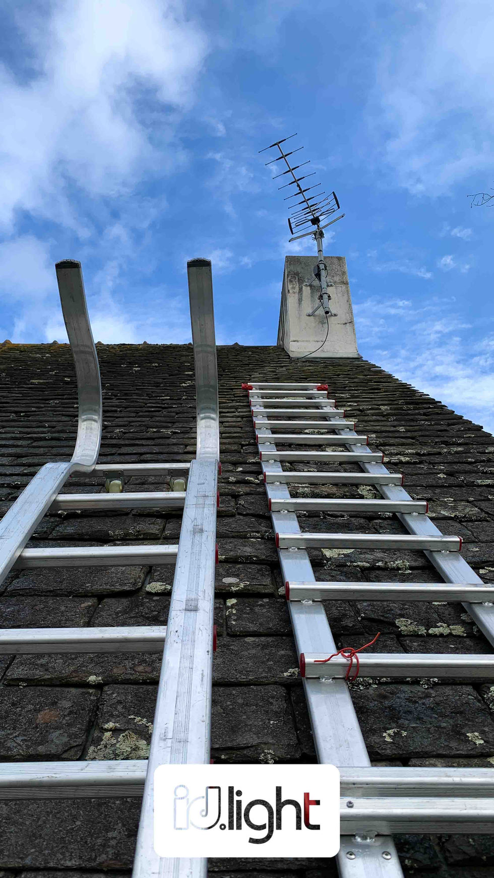 Deux échelles sur un toit avec une antenne râteau accrochée, installée par votre antenniste à Questembert, Claude Defiolle.