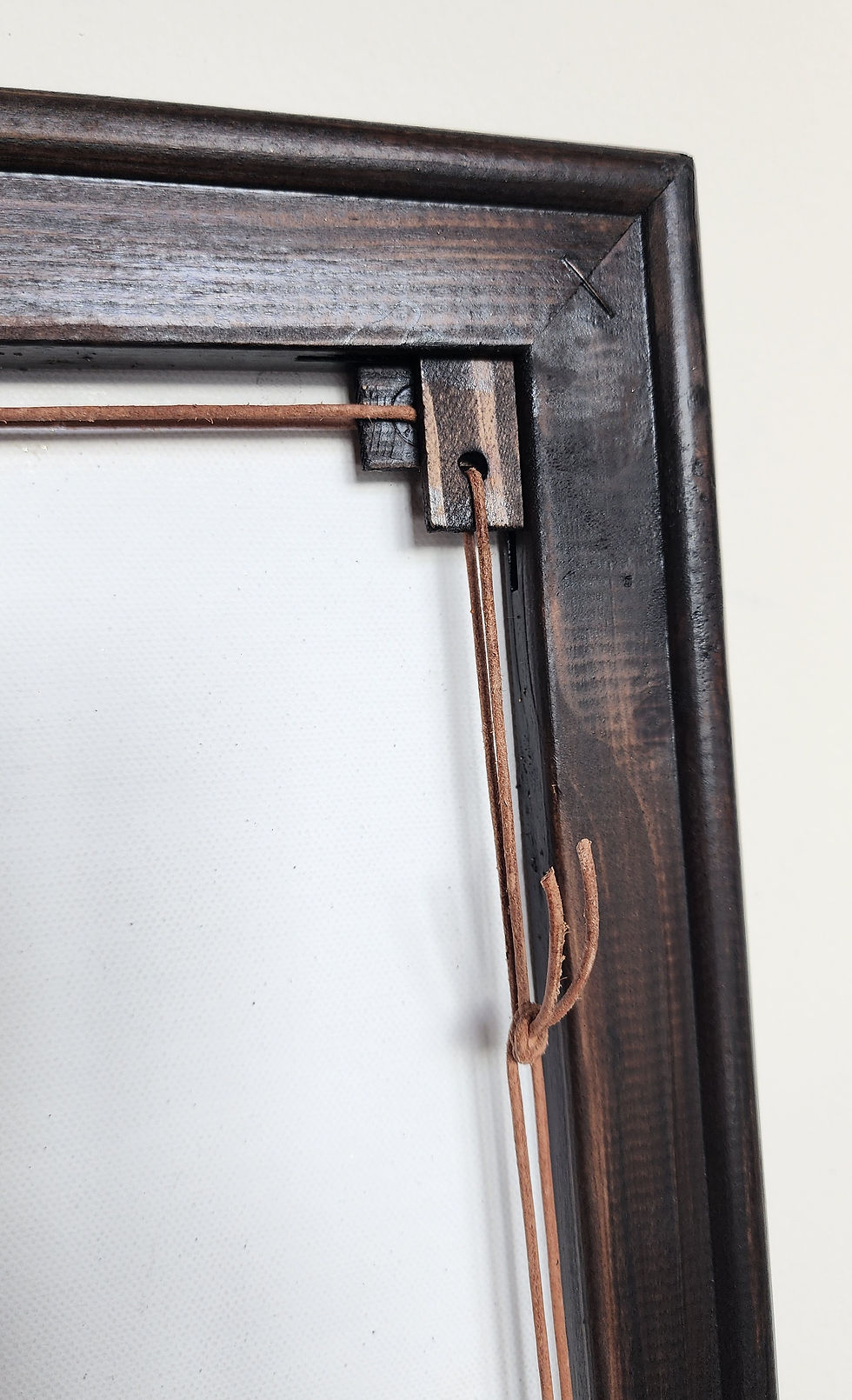 Close-up view of a wooden frame with a natural finish around a colorful abstract painting