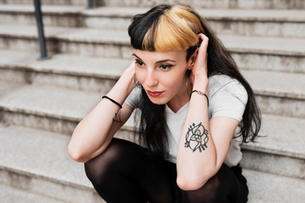 woman on a step with tattoed arm