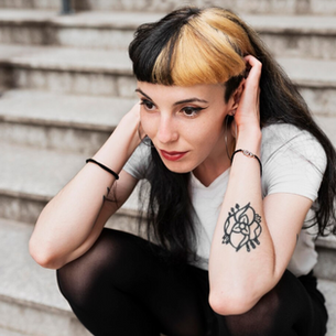 woman on a step with tattoed arm