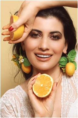 girl with shining white teeth holding an orange