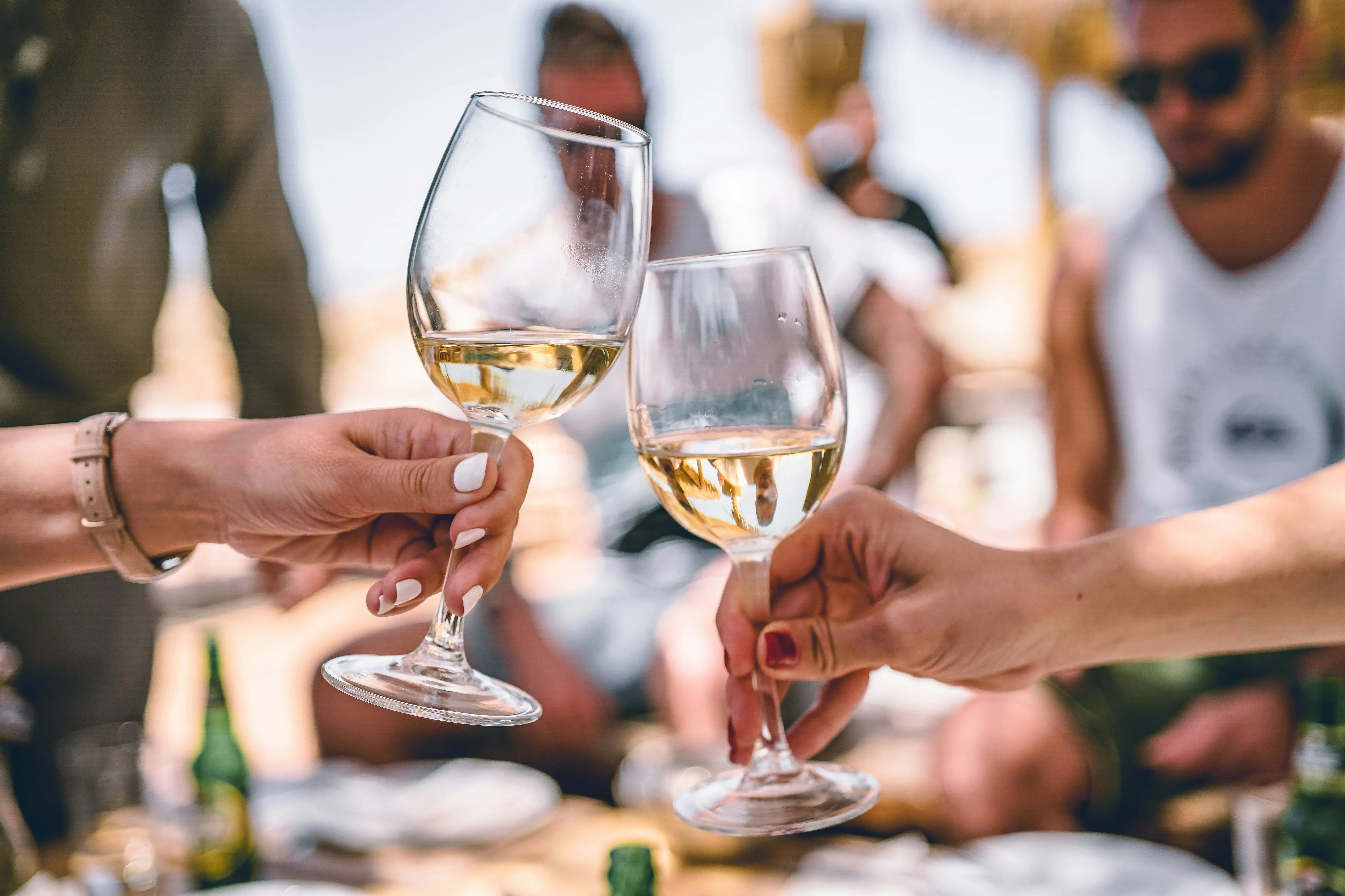 Hands holding wine glasses toasting to good times at SLO Wine Mixer, held June 6th, at Madonna Expo Center