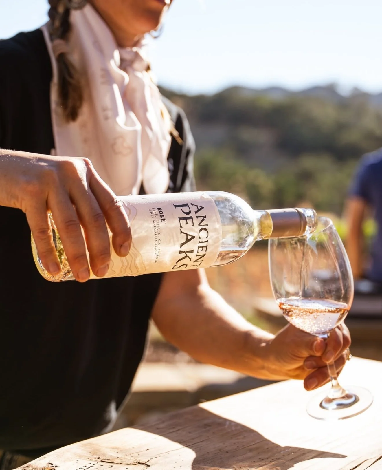 Female server pours a glass of crisp white wine