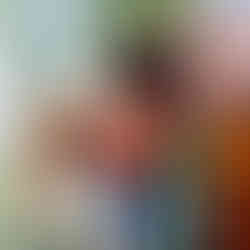 A group of people are looking at pictures on a wall.