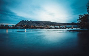 Barrage de Poses illuminé au crépuscule, ambiance bleutée et reflets sur la Seine en Normandie