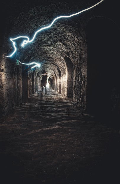 Silhouettes dans un tunnel de lumière scène ésotérique représentant le passage entre vie et mort