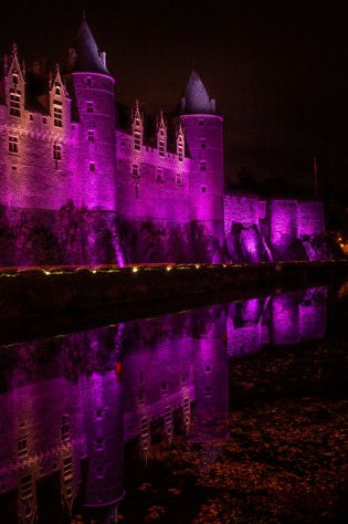 Château de Josselin de nuit avec éclairage mauve en Bretagne