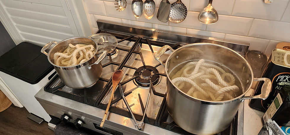 Hand dyeing small batches of cotton rope leashes with salted dye baths in the kitchen.
