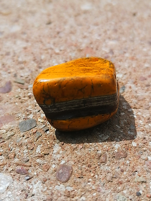 Muggle Stone spiritual crystal and tumbled stone on paved holistic and natural background