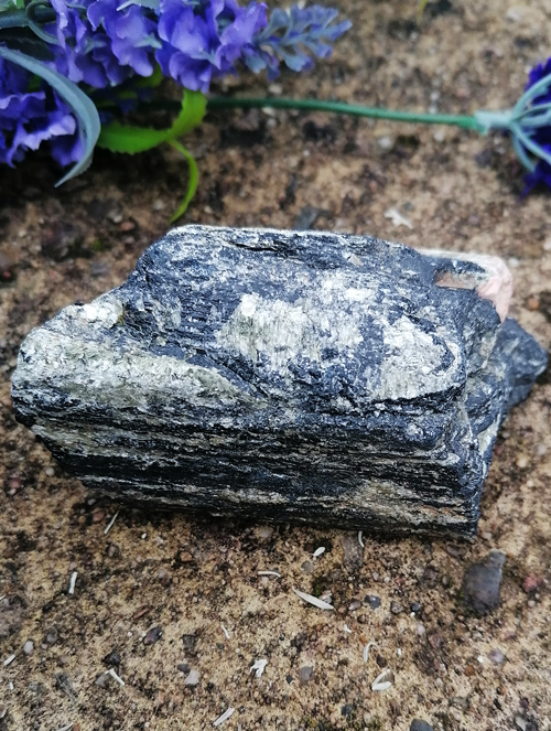 Tourmaline spiritual healing crystal and tumblestone on paved holistic and natural background