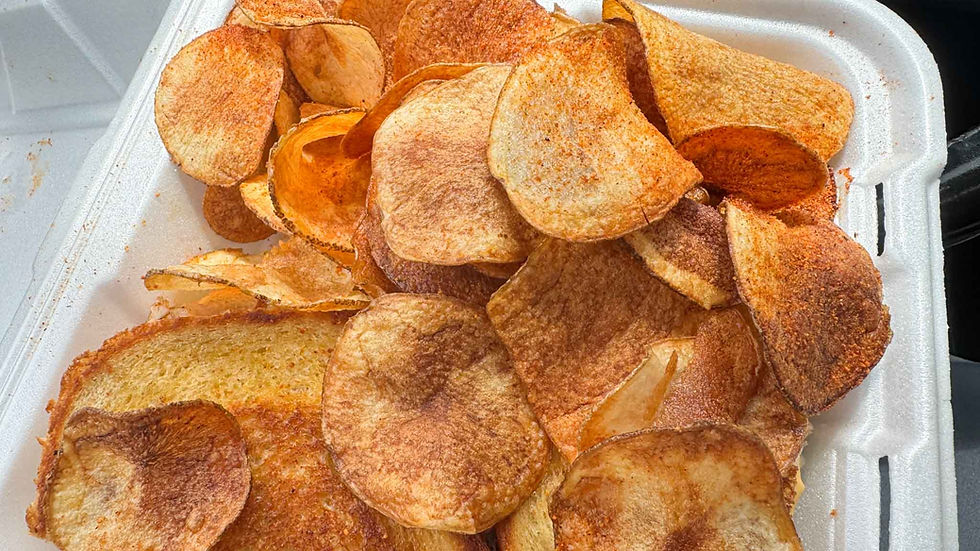 Pile of seasoned rock chips and potato chips in a white foam takeout container, golden-brown and crispy with no text visible.