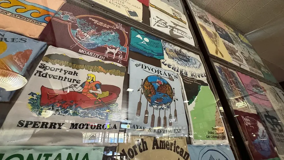 T-Shirts from rafting trips on a wall inside a restaurant