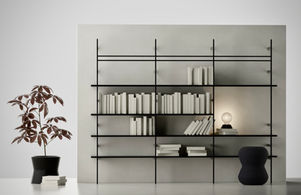 modellazione 3d di uno scaffale di design, con libri, una luce da tavolo, un acero e un pouff in plastica grigio scuro.