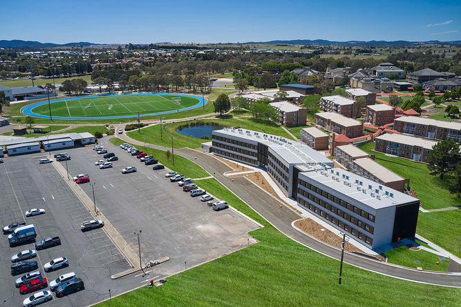 Residents walking through landscaped communal garden with benches, trees, and children’s play area between residential buildings. Close-up of modern facade featuring mixed cladding materials, glass balconies, and aluminum louvers on a multi-residential apartment building. Buildings sky scraper, common spaces gardens connivence, architecturally designed, balconies windows. green spaces, ocean views Bruce Robinson Photography