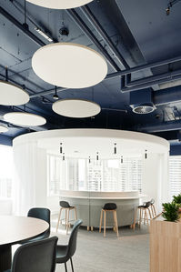 Modern commercial interior with circular bar seating and suspended ceiling lights. Contemporary commercial fit-out in Sydney featuring a circular bar-style seating area, soft furnishings, and suspended round ceiling lights. Modern commercial fit-out in Sydney showcasing a circular bar and seating area, soft furnishings, exposed services, and layered ceiling lighting. A refined modern commercial interior in Sydney with a circular bar-style seating hub, suspended round ceiling lights, exposed ceiling services, and city views beyond.Contemporary commercial interior with circular seating and ceiling lighting.