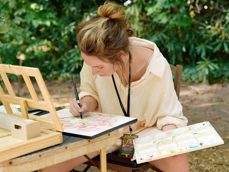 Artist Morgan Pallas painting an outdoor scene.