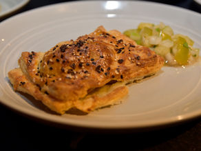 Breakfast pastry with a side of relish on a plate.