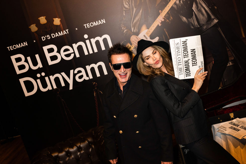 D'S Damat lansman etkinliğinde marka duvarı önünde poz veren Tülin Şahin ve Teoman PR fotoğrafı.