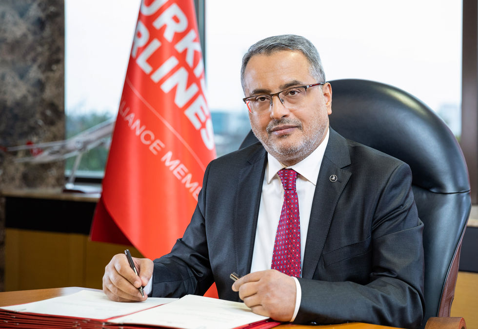 Türk Hava Yolları CEO'su Ahmet Bolat masasında belge imzalarken çekilmiş kurumsal iletişim fotoğrafı. Arka planda THY flaması bulunan PR ve yönetici portresi.