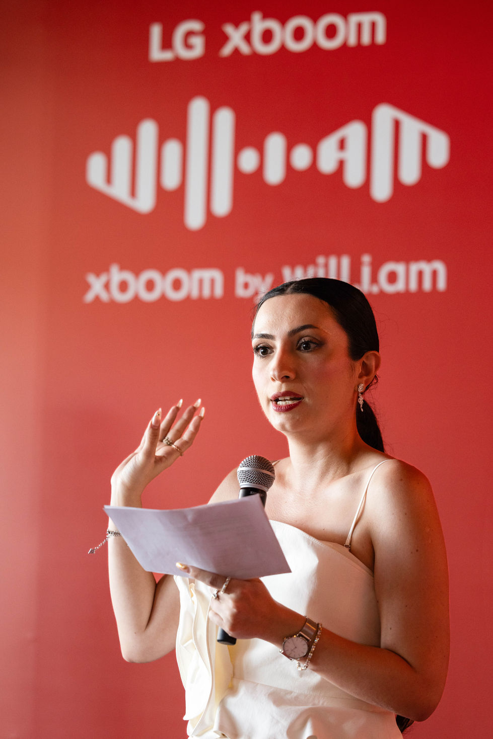 LG XBOOM reklam lansmanı basın toplantısında sahnede açılış konuşmasını gerçekleştiren sunucu ve etkinlik atmosferi.