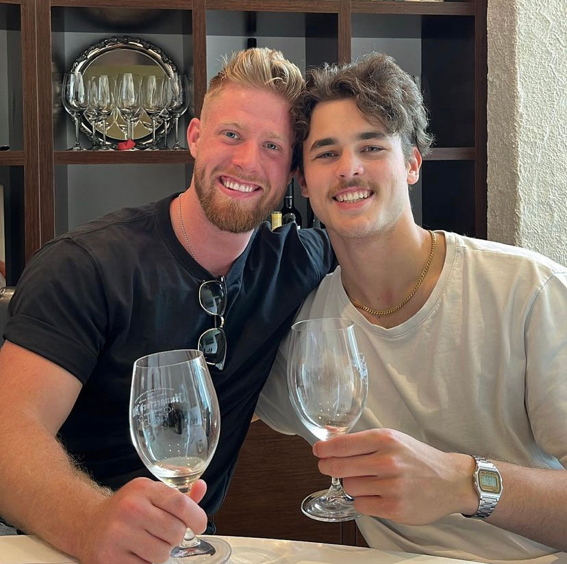 Quentin Geczy holding wine glasses with friend