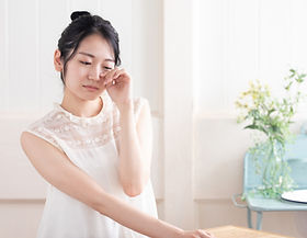 目に手をあてる女性