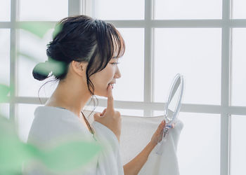 鏡で歯茎を見る女性