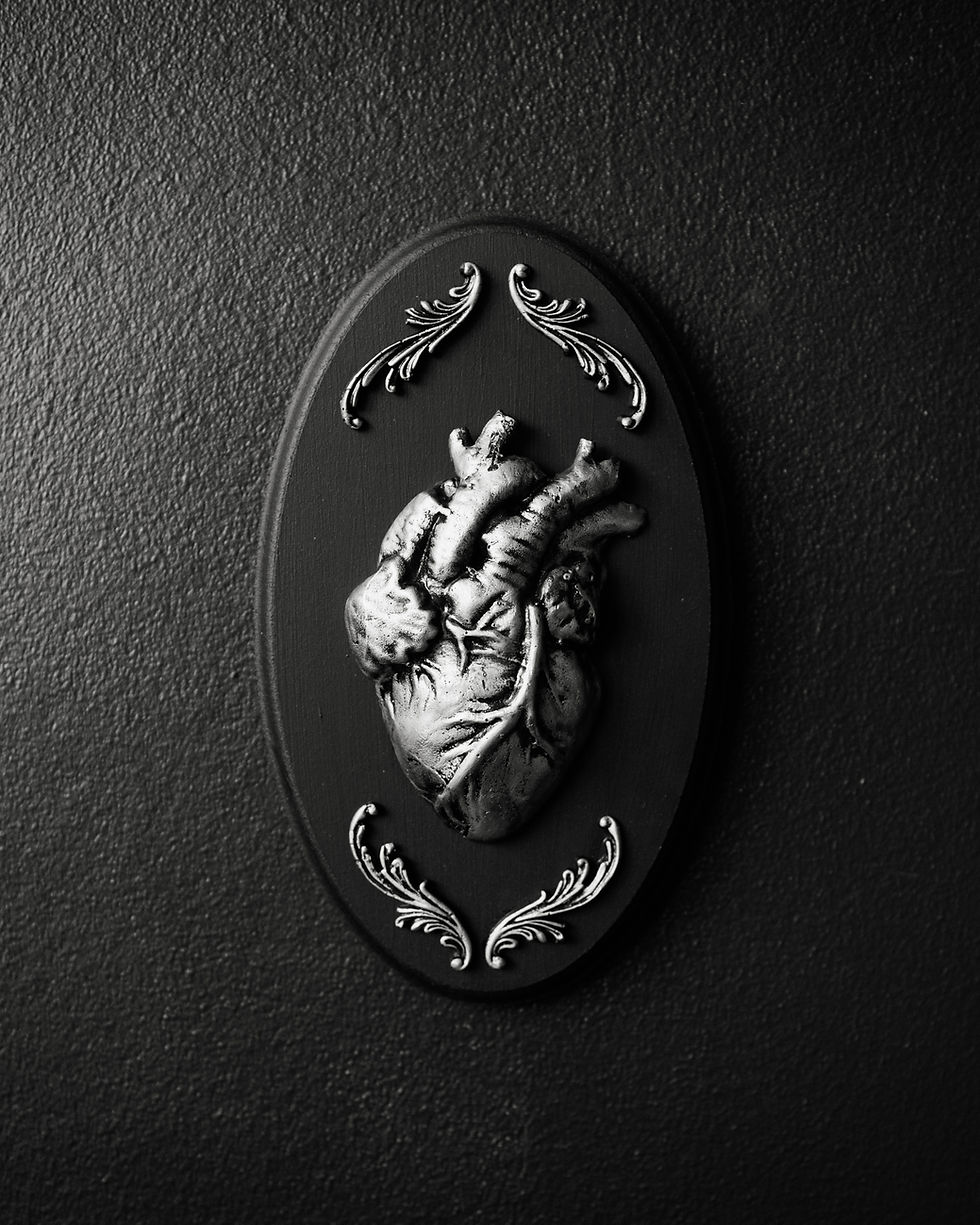 Thumbnail: Oval gothic wall plaque featuring a raised jesmonite anatomical heart sculpture mounted on a dark MDF backing.
