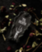 A black, coffin-shaped wall plaque with "’Til Death" in white Gothic lettering and a white skeletal hand beneath it.