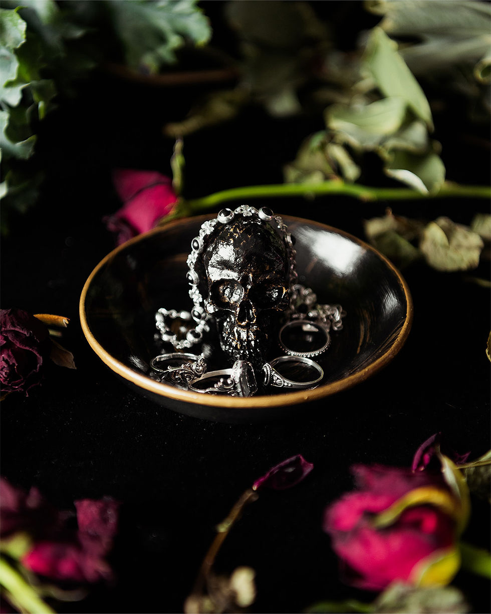 Thumbnail: Glossy black trinket dish with a gold rim and accents, with a black and gold skull in the centre, surrounded by jewellery.