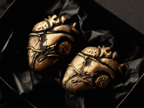 A pair of anatomical heart magnets with a vintage-gold effect finish.