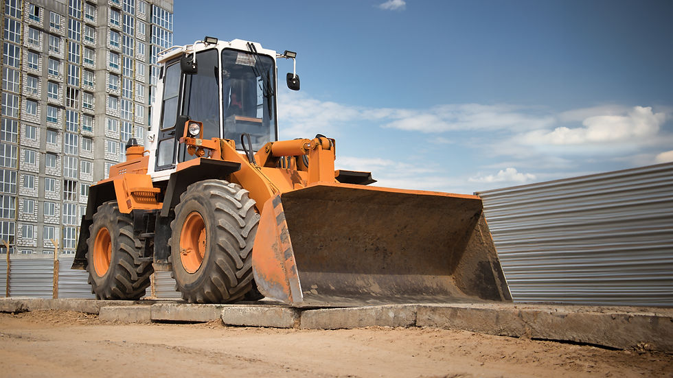 A powerful bulldozer is parked in front of a weathered building, ready for action.jpg