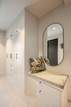 Garderobe og sittebenk med en myk og elegant farge i Jotun Smooth White NCS 2003-G96Y. Den gyldne gråhvite tonen gir et lyst og luftig preg, mens den grønne undertonen gir rommet en varm og koselig følelse. Malte slette fronter gir et moderne og minimalistisk uttrykk