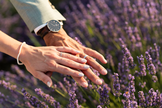 the hands of the bride and groom above the lavender