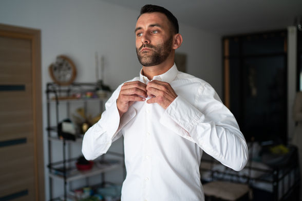 le marié boutonne sa chemise