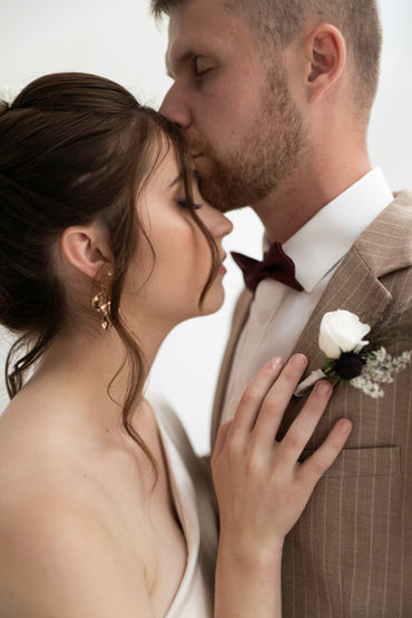 Marié embrassant doucement sa mariée sur le front, romantique à Lyon