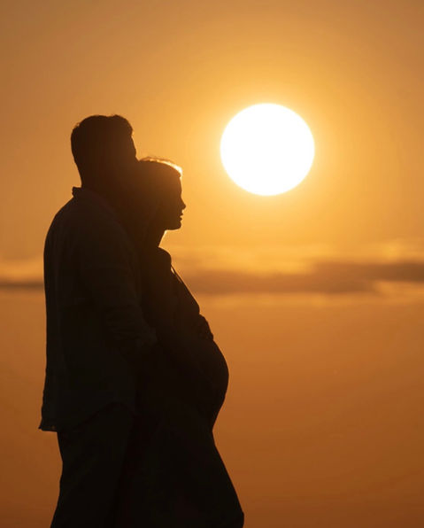 Couple au coucher du soleil pendant une grossesse