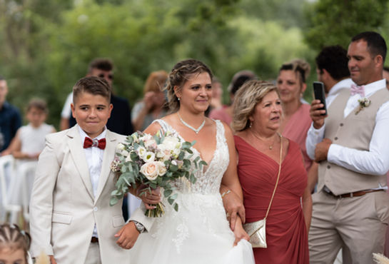 Mariée avec bouquet, accompagnée d'un garçon et d'une femme.