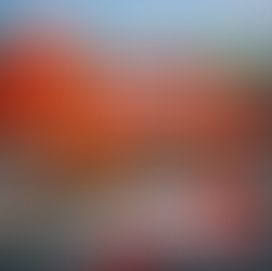 Loja da Tumelero em destaque com fachada vermelha e amarela, bandeiras da marca e do Brasil, caminhão de entrega estacionado na frente, materiais de construção expostos na entrada e elementos gráficos que representam crescimento no mercado e expansão regional no Rio Grande do Sul.