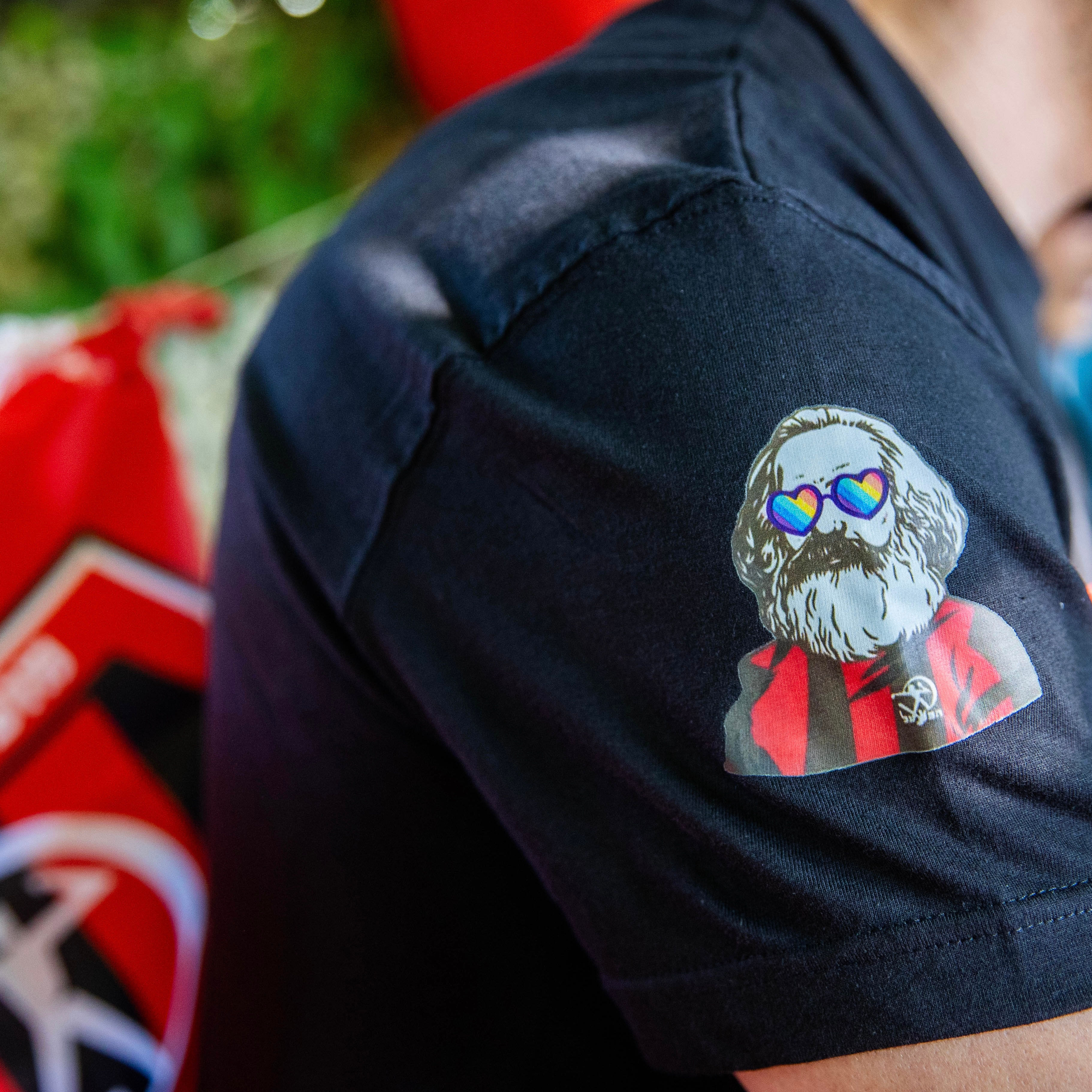 שרוול ימין עם קארל מארקס עם חולצת הפועל ומשקפי לבבות בצבעי גאווה