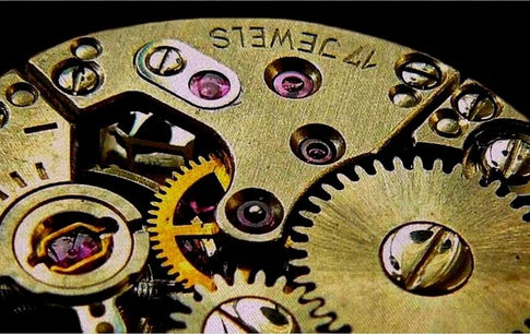 Maître horloger jurassien ajustant le mécanisme d’une montre dans son atelier à Morbier, symbole du savoir-faire horloger du Jura.