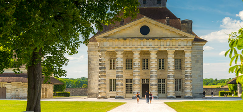 Vue aérienne de la Saline Royale d'Arc-et-Senans, site classé UNESCO dans le Jura. Découvrez un patrimoine historique exceptionnel à travers des parcours touristiques responsables et authentiques.