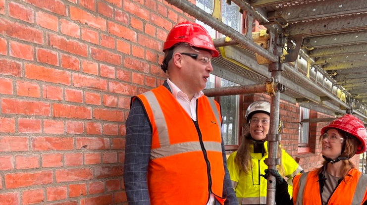 David Sandrén, kommunstyrelsens ordförande, Helen Treslow, senior byggprojektledare VFAB och Anna Bengtsson, ordförande förskole- och grundskolenämnden vid den omfogade tegelfasaden.